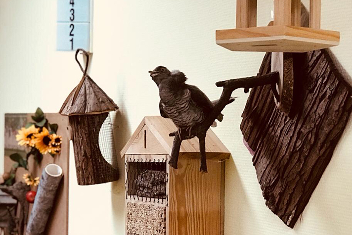 Holzgeschnitztes Vogelhaus an der Wand