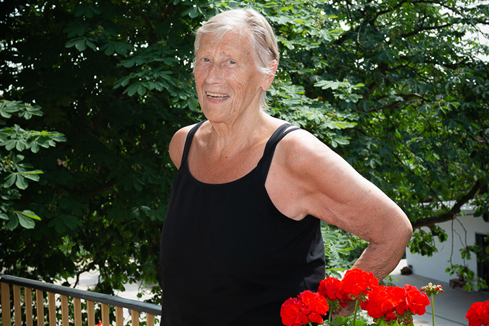 Eine Bewohnerin steht auf ihrem Balkon