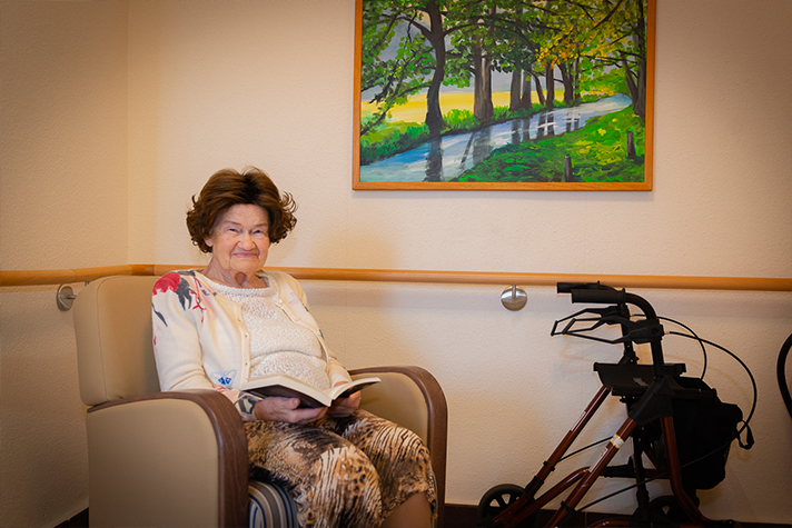 Glückliche Bewohnerin im Sessel